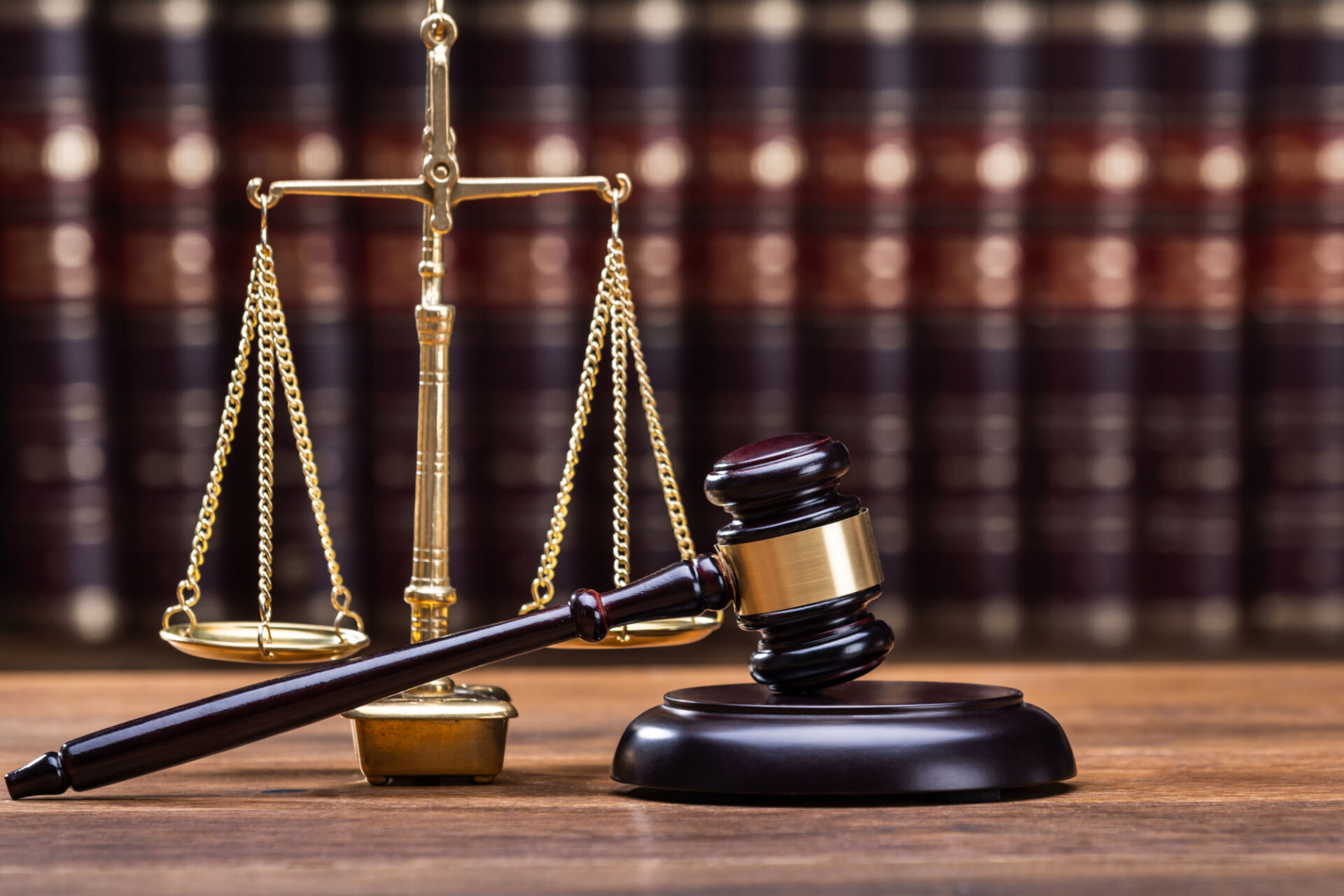 Wooden Gavel With Golden Scale On Table